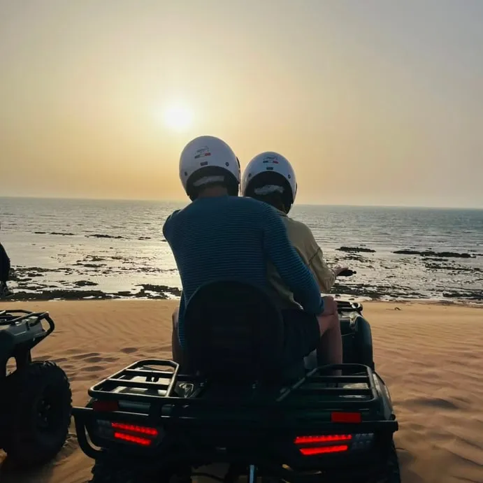 Riders watching the sun go into the Atlantic from the dunes
